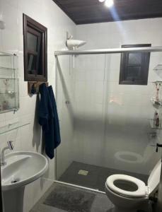 a white bathroom with a toilet and a sink at Lar Zen in Garopaba