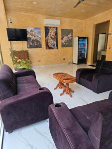 a living room with purple couches and a table at Hotel El Paraíso Calakmul - Jungle Experience in Xpujil