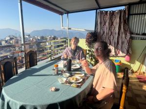 a man and woman sitting at a table with food at Sunshine homestay in Tānsen