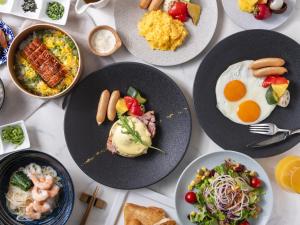 a table full of plates of food with breakfast foods at Mitsui Garden Hotel Nagoya Premier in Nagoya