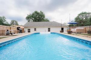 a large blue swimming pool in front of a house at Spacious 4BR Home Pool and Comfort in Columbus