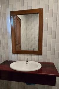 a bathroom with a sink and a mirror at Nongsak Riverside Guesthouse & Nongsak Guesthouse in Ban Khon
