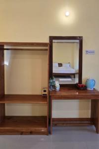 a room with two wooden shelves and a mirror at Nongsak Riverside Guesthouse & Nongsak Guesthouse in Ban Khon