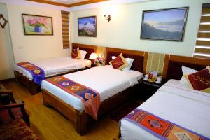 a hotel room with three beds in it at Hotel Sao Xanh in Sapa