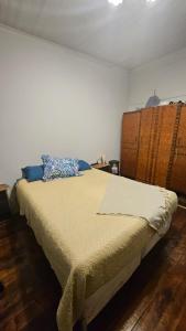 a bedroom with a large bed with a wooden headboard at Hostel Varas in Viña del Mar