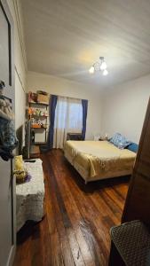 a bedroom with a bed and a wooden floor at Hostel Varas in Viña del Mar
