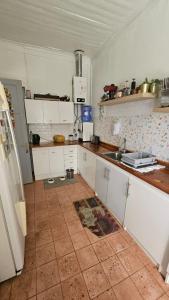 a kitchen with white cabinets and a tile floor at Hostel Varas in Viña del Mar