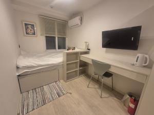 a small room with a desk and a bed and a tv at Seoul On Stay in Seoul
