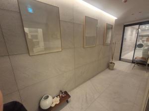 a tiled hallway with a vase on a wooden shelf at Seoul On Stay in Seoul +4 photos