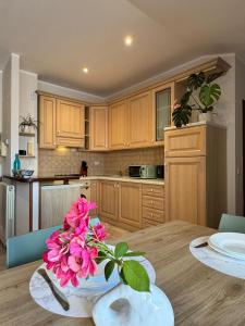 a kitchen with a table with a vase of pink flowers at Bella Todi Apartment in Todi