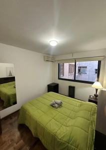 a bedroom with a green bed and a mirror at Espacio necochea in Mendoza