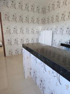 a room with a counter and a wall with wallpaper at Cantinho das Joaninhas in Prado