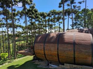 a large wooden barrel in a park with trees at Pousada Villa Barril in Monte Verde