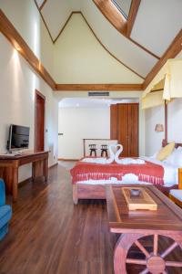 a bedroom with a bed and a desk and a tv at Vangvieng Lina hotel in Vang Vieng