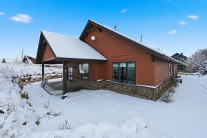 a cabin in the snow with snow on the ground at Trappers Ridge Powder Haven in Eden