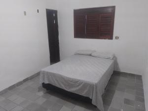a small bed in a room with a window at Melos hospedagem jp in João Pessoa