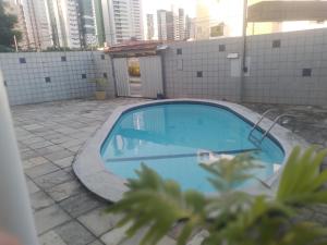 a large blue swimming pool on a building with tall buildings at Melos hospedagem jp in João Pessoa