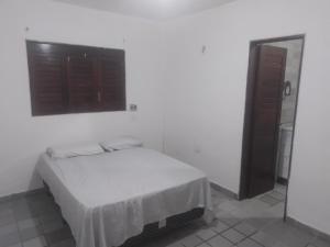 a white room with a bed and a window at Melos hospedagem jp in João Pessoa