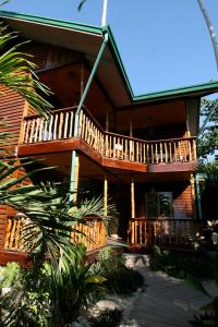 a large wooden house with a balcony on it at La Salangane Caalan Beach Villa in El Nido