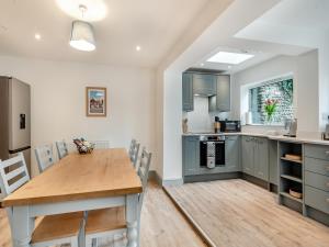 a kitchen with a wooden table and a dining room at Stones Throw Cottage in Sheringham