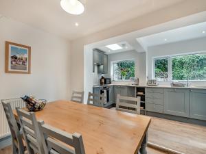 a kitchen and dining room with a wooden table and chairs at Stones Throw Cottage in Sheringham
