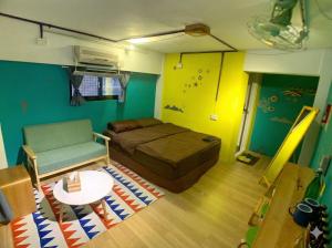 a room with a bed and a table and a couch at 英倫 旅店 in Tainan