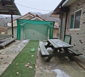 a picnic table in a backyard with a ping pong net at Hwacheon Ujune Minbak in Hwach'ŏn