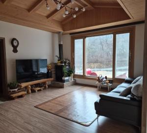 a living room with a couch and a flat screen tv at Hwacheon Ujune Minbak in Hwach'ŏn