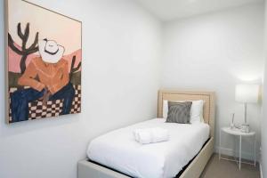 a bedroom with a bed with a painting on the wall at Boutique 1B2B HighRise Condo in CBD in Melbourne