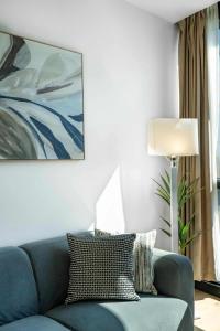 a living room with a blue couch and a lamp at Boutique 1B2B HighRise Condo in CBD in Melbourne