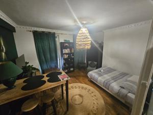 a living room with a bed and a table at Bel Apt châteaux de Vincennes in Vincennes