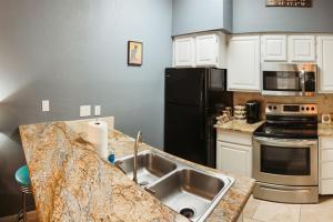 a kitchen with a sink and a black refrigerator at Stylish Island Villa on Lake Travis in Lago Vista