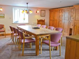 a dining room with a wooden table and chairs at The Barn in Waberthwaite