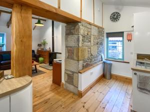 a kitchen and living room with a stone fireplace at No2 The Neuk in Belford
