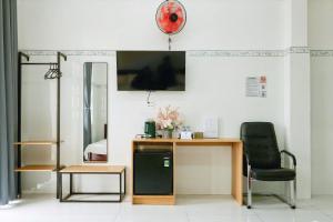 a room with a desk and a chair and a mirror at Nhà Khách Vạn Thành in Cà Mau
