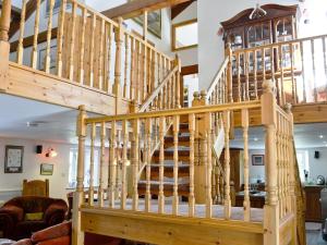 a wooden staircase in a living room with a wooden stair case at The Barn in Waberthwaite