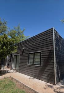 a black house with a window on the side of it at Termas Del Vino 2 in Palmilla Abajo