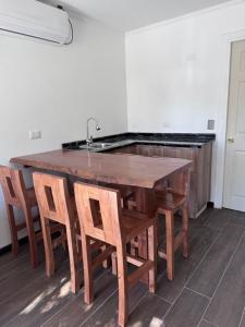 a kitchen with a wooden table with chairs and a sink at Termas Del Vino 2 in Palmilla Abajo