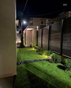 a backyard at night with a fence and grass at Kalvokoresi 16 I Premium Apartments in Chios