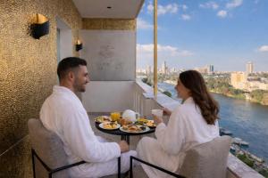 a man and a woman sitting at a table with food at Casa Figueroa - Boutique Hotel- Adults Only in Cairo