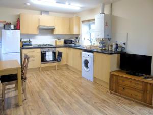 a kitchen with a washer and dryer in it at Tan Rallt Barn in Tregarth
