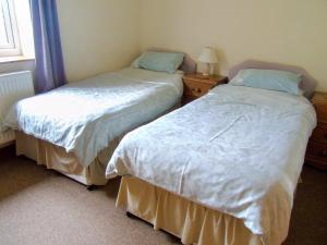 two beds sitting next to each other in a bedroom at Tan Rallt Barn in Tregarth +7 photos