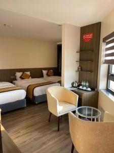 a hotel room with two beds and a chair at Lạng Sơn Marina Hotel in Lạng Sơn