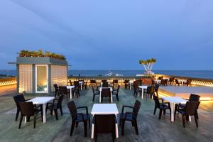 a restaurant with tables and chairs on a deck at Hisea Huahin Hotel in Hua Hin