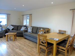 a living room with a couch and a table at Tan Rallt Barn in Tregarth