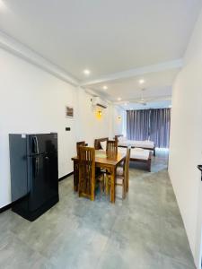 a kitchen and dining room with a table and a refrigerator at Yehara Apartments in Weligama +23 photos