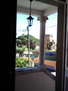 d'une fenêtre donnant sur un balcon avec une lumière de rue. dans l'établissement Villa Charme, à Estoril