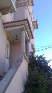 biały budynek z gankiem i drzwiami w obiekcie Villa Charme w mieście Estoril