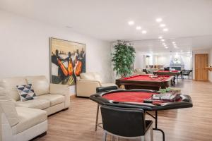 a living room with couches and a pool table at Waterfront Mansion with Mont-Saint-Hilaire Views, Near Montreal in Beloeil Village