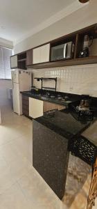 a kitchen with a black counter top in a room at Loft proximo a orla 02 in Presidente Epitácio